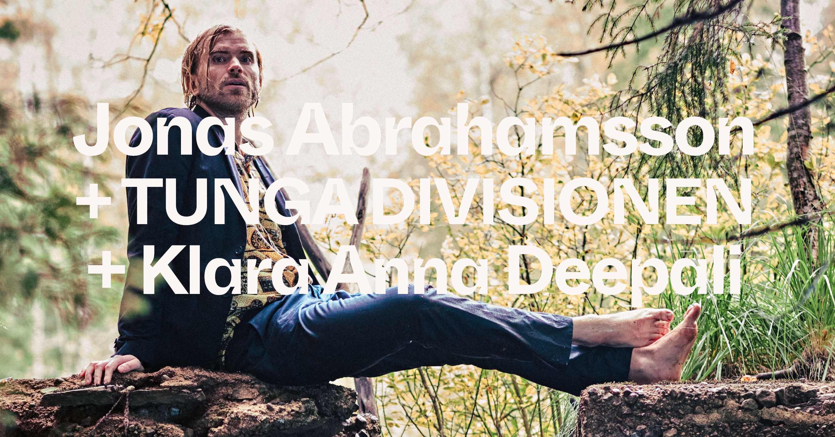 A man in a suit sits barefoot on a rock in a forest, with large text overlaying the image.