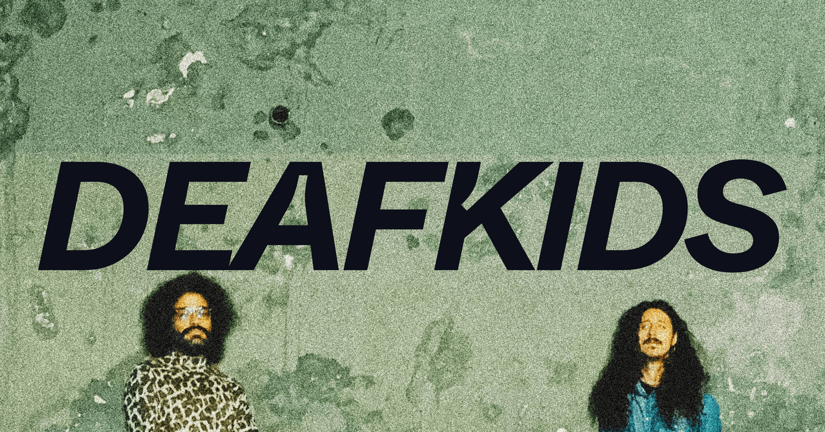 Two individuals stand against a textured green wall with the word "DEAFKIDS" in bold, black letters above them.